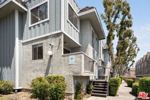 Front view of a multi-story building with exterior stairs and large windows.