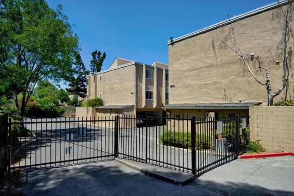 Front view of a multi-story building with a gated entrance.