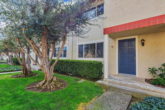 Front view of a building with a blue door and a small porch area.