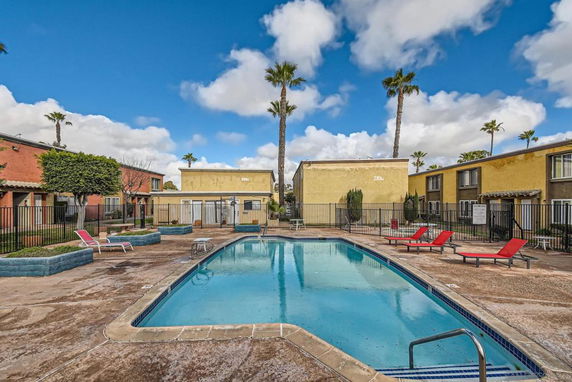 Outdoor swimming pool area with surrounding residential buildings.