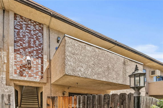 Front view of a multi-story building with a brick accent and textured walls.
