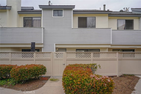 Front view of a multi-story house with fenced entrance