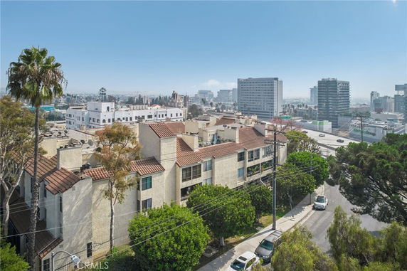 Panoramic view of a residential area with apartment buildings and cityscape in the background.