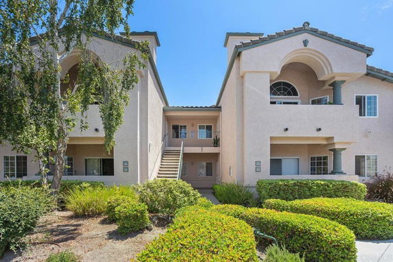 Front view of a two-story residential building with archways and balconies.