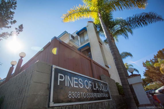 Front view of a multi-story building with a sign reading 'Pines of La Jolla'.