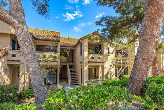 Front view of a two-story residential building with balconies and stairs.