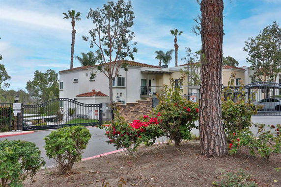 Front view of a multi-story building with decorative gates and garden.