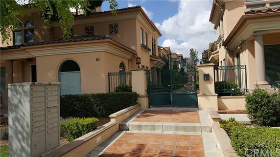 Front view of a multi-story house with a gated entrance.