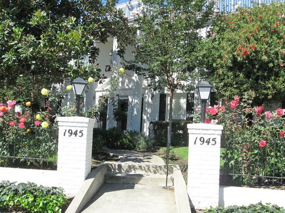 Front view of a two-story building with a pathway and garden.