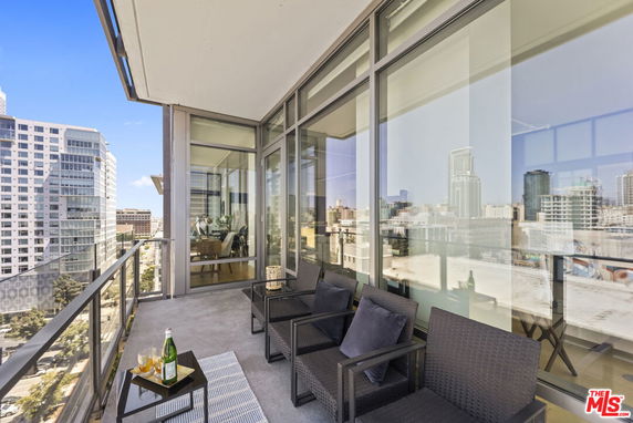 Balcony view from a high-rise building showing surrounding cityscape.