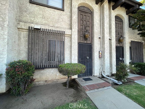 Front view of a two-story building with decorative wooden shutters and gated doors.