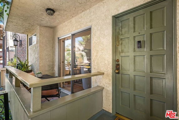 Front view of a house entrance with a green door and outdoor seating area.