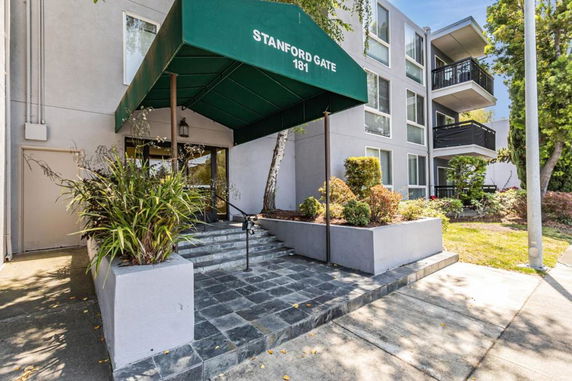 Front view of a multi-story building with a green awning entrance.