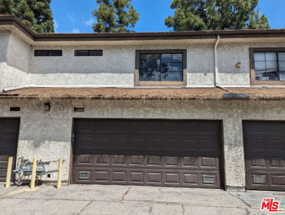 Front view of a building with a double garage and upper floor windows.