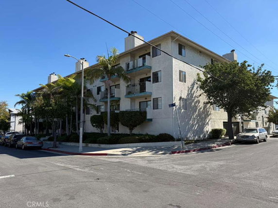 Front view of a multi-story apartment building on a street corner.
