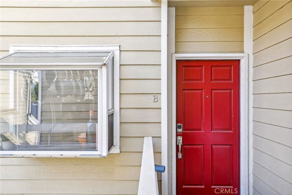 Entrance with a red door and adjacent window on a beige exterior wall.