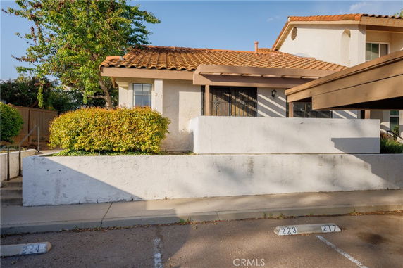 Front view of a house with a tile roof and white exterior walls.