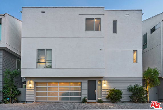 Front view of a modern multi-story house with a two-car garage and minimalistic design.