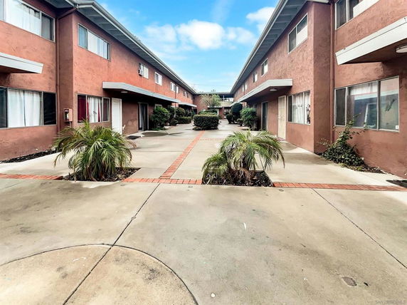 Front view of a two-story apartment building with a courtyard.