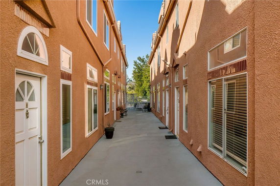 Narrow outdoor view between two multi-story buildings with similar design and color