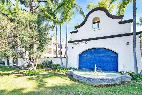 Front view of a building with a blue tiled wall and fountain.