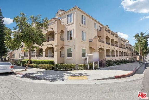 Front view of a multi-story apartment building with balconies.