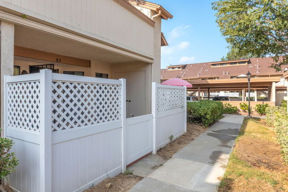Partial front view of a residential building with a white lattice fence.