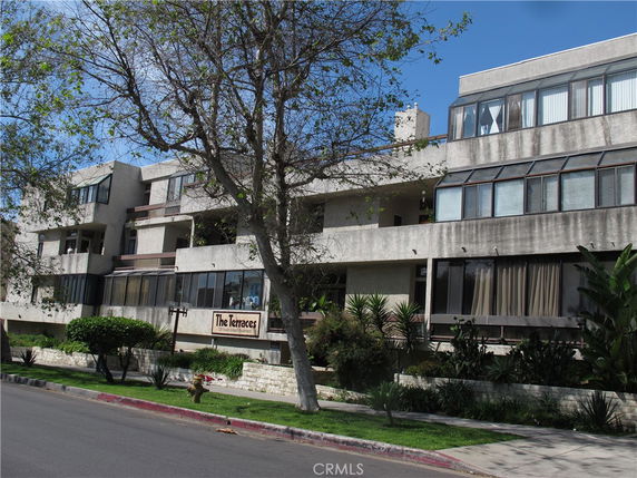 Front view of a multi-story building with large windows and a sign reading 'The Terraces'.