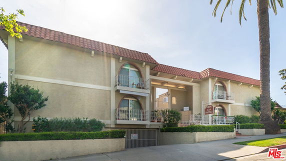 Front view of a two-story building with balconies and a tile roof.
