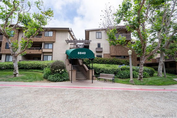 Front view of a multi-story residential building with a central entrance canopy.