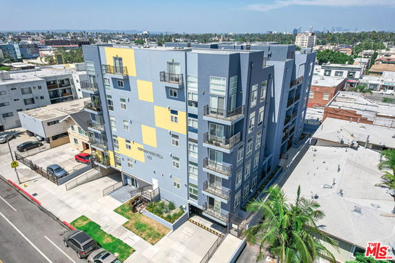Front view of a multi-story apartment building with a modern design and balconies.