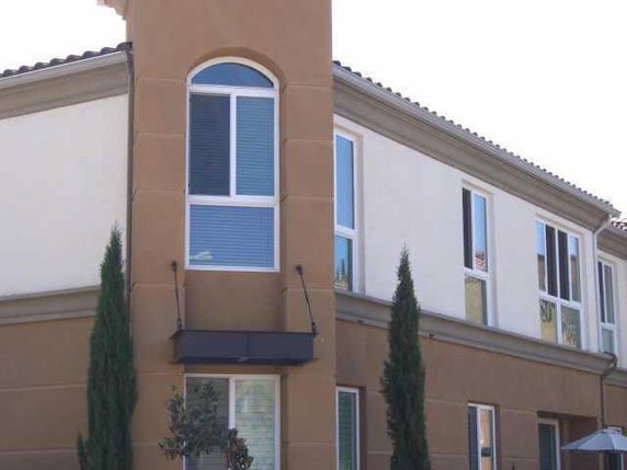 Front view of a two-story house with large windows and a brown facade.