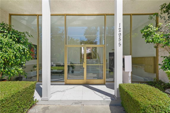 Front view of a building with a glass entrance and columns.