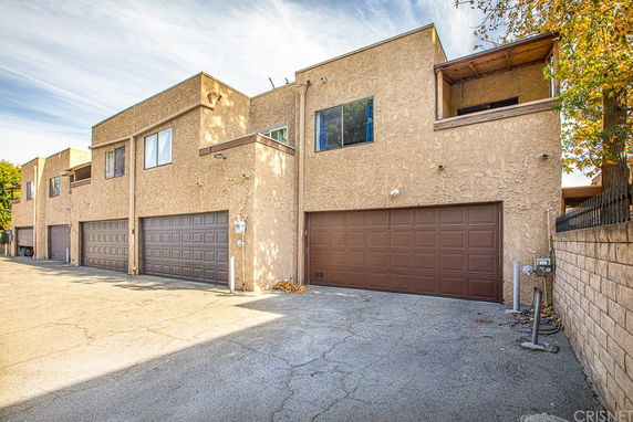 Front view of a building with multiple garage doors and upper-level windows.