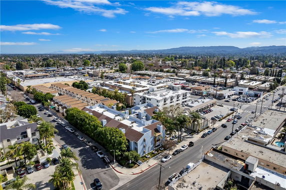 Panoramic view of a residential and commercial area with several buildings and distant mountains.