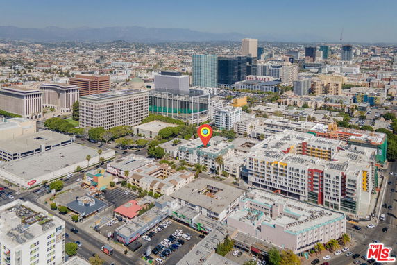 Aerial view of a cityscape with multiple commercial and residential buildings.