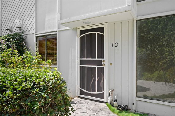 Front view of a building entrance with a door and nearby window.