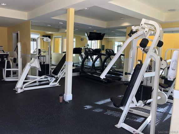 Indoor gym area with exercise machines and treadmills.