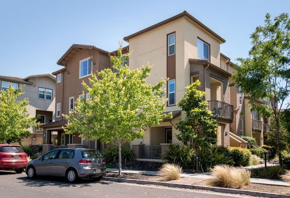 Front view of a modern multi-story house with balconies and large windows.