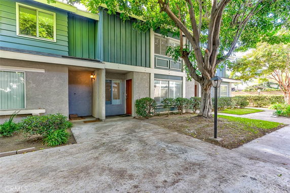 Front view of a two-story townhouse with green and gray exterior.
