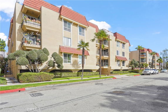 Front view of a multi-story apartment building with balconies.