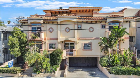 Front view of a multi-story building with a Mediterranean architectural style.