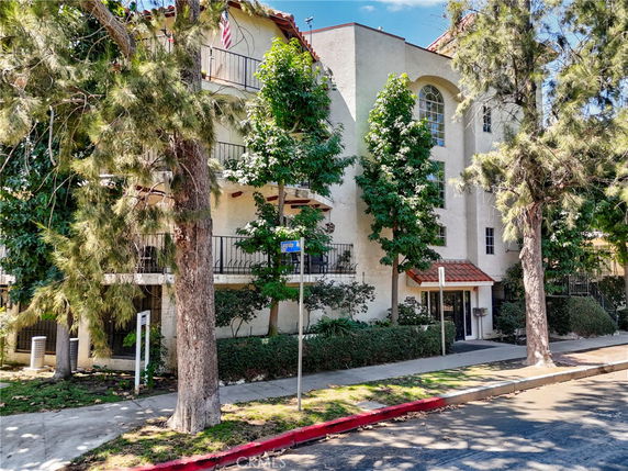 Front view of a multi-story building surrounded by trees.
