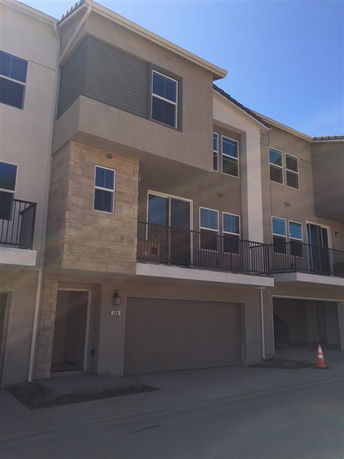 Front view of a multi-story house with a garage and balcony.