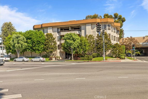 Front view of a multi-story apartment building on a street corner.