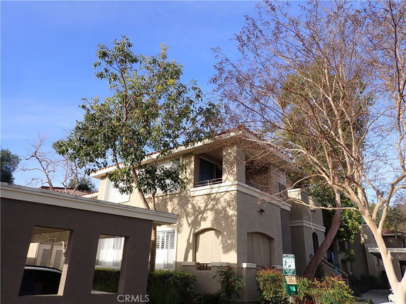 Front view of a two-story building with trees nearby.