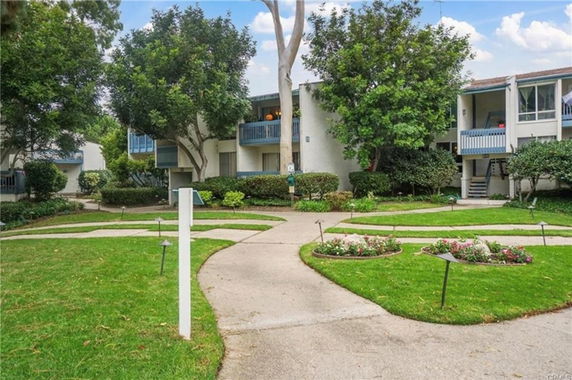 Front view of a multi-unit residential building with balconies and pathways.