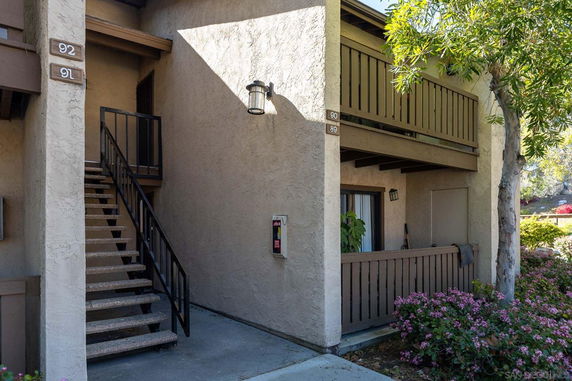 Front view of a two-story building with stairway access and balconies.