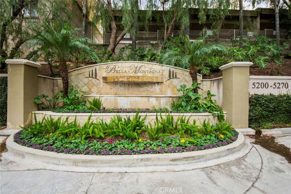 Front view of a building entry sign with landscaping.