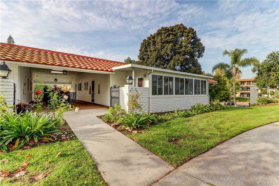 Front view of a single-story house with a red-tiled roof and covered walkway.